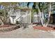 Backyard with brick pavers, mature landscaping, a stairway up to the home, and tropical plants at 610 Alligator Dr, Venice, FL 34293
