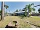 Spacious backyard with fire pit, surrounded by lush landscaping and privacy fence at 610 Alligator Dr, Venice, FL 34293