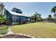 Expansive backyard featuring stepping stone pavers, a screened-in pool, and tropical landscaping at 610 Alligator Dr, Venice, FL 34293