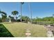 Spacious grassy yard with stepping stone pavers, mature trees, and a wooden fence at 610 Alligator Dr, Venice, FL 34293
