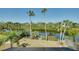 Scenic backyard with waterfront access, lush greenery, and palm trees, creating a private oasis at 610 Alligator Dr, Venice, FL 34293