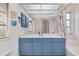 Bathroom features a blue vanity with a large mirror, and a tub shower combination at 610 Alligator Dr, Venice, FL 34293