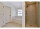 Bathroom showcasing a soaking tub, window, tile floors, and a glass enclosed shower at 610 Alligator Dr, Venice, FL 34293