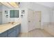 Bathroom featuring dual sinks, vanity, a large soaking tub, and white-painted doors at 610 Alligator Dr, Venice, FL 34293