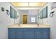Bathroom featuring dual sinks, vanity, ample cabinet space, and tile floors at 610 Alligator Dr, Venice, FL 34293