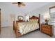 Bright bedroom featuring light-colored wood floors, Tommy Bahama-style furniture, and a ceiling fan at 610 Alligator Dr, Venice, FL 34293