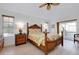 Comfortable bedroom featuring a ceiling fan, ensuite bathroom, and ample natural light from large windows at 610 Alligator Dr, Venice, FL 34293