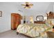 Bright bedroom with wood floors, Tommy Bahama-style furniture, ceiling fan, and double doors at 610 Alligator Dr, Venice, FL 34293
