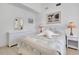 Bright bedroom featuring white furniture, ceiling fan, coastal decor, and light-colored wood floors at 610 Alligator Dr, Venice, FL 34293