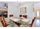 Dining room with table sits adjacent to modern kitchen with stainless appliances and view of the home's entryway at 610 Alligator Dr, Venice, FL 34293