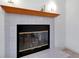 A close-up of a fireplace with white tile and wooden mantle at 610 Alligator Dr, Venice, FL 34293