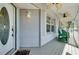 Inviting front porch with rocking chairs, ceiling fans, and large windows, creating a relaxing space at 610 Alligator Dr, Venice, FL 34293