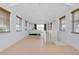 Open living space with light tile flooring, large windows and sliding glass door to patio at 610 Alligator Dr, Venice, FL 34293