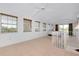 Spacious living room area featuring tile floors, large windows, and staircase at 610 Alligator Dr, Venice, FL 34293