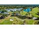 Aerial view of the community clubhouse, ponds, and golf course with lush greenery at 611 Paget Dr, Venice, FL 34293