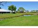 Inviting backyard with a serene pond view, lush greenery, and a peaceful atmosphere at 611 Paget Dr, Venice, FL 34293