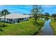 Serene backyard featuring a lush lawn and tranquil pond view with mature tropical landscaping at 611 Paget Dr, Venice, FL 34293