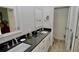 Well-lit bathroom featuring double sinks, granite countertops, and modern fixtures at 611 Paget Dr, Venice, FL 34293