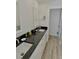 Bathroom featuring granite countertops, double sinks, white cabinetry, and a mirror at 611 Paget Dr, Venice, FL 34293