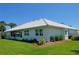 Beautiful rear exterior view featuring a tiled roof, screened enclosure, and well-kept landscaping at 611 Paget Dr, Venice, FL 34293