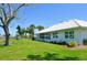 Exterior shot featuring the rear of the home, backing onto a lake and lush landscaping at 611 Paget Dr, Venice, FL 34293