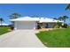 Beautiful single-story home with white tile roof, a neatly kept lawn, and lovely curb appeal at 611 Paget Dr, Venice, FL 34293