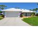 Welcoming single-story home featuring a white tile roof, well-maintained lawn, and inviting landscaping at 611 Paget Dr, Venice, FL 34293