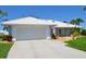 Charming single-story home with a white tile roof, pristine driveway, and meticulously maintained landscaping at 611 Paget Dr, Venice, FL 34293