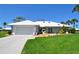 Charming single-story home with a white tile roof, well-manicured lawn, and attractive landscaping at 611 Paget Dr, Venice, FL 34293