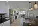 Bright kitchen featuring stainless appliances, granite counters, white cabinets, pendant lighting and laminate flooring at 611 Paget Dr, Venice, FL 34293