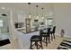 Kitchen with a granite island, stainless appliances, white cabinets, and black leather bar stools at 611 Paget Dr, Venice, FL 34293