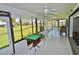 Enclosed lanai with tile flooring and views of the serene backyard and pond at 611 Paget Dr, Venice, FL 34293