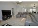 Spacious living room with modern ceiling fan, vaulted ceilings, and a large leather sectional at 611 Paget Dr, Venice, FL 34293