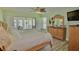 Main bedroom with light green walls, wood-look flooring, and sliding glass door to outdoor patio at 611 Paget Dr, Venice, FL 34293