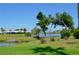 Picturesque view of the pond, surrounded by mature trees and manicured landscaping at 611 Paget Dr, Venice, FL 34293