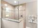 Glass enclosed shower with granite ledge and neutral toned tile at 6126 Spinnaker Blvd, Englewood, FL 34224