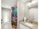 Well-lit bathroom with granite countertop vanity, stylish mirror, and colorful shower curtain at 6126 Spinnaker Blvd, Englewood, FL 34224