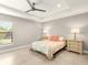 Well-lit bedroom with a ceiling fan, neutral colors, and tile flooring at 6126 Spinnaker Blvd, Englewood, FL 34224