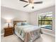 Bright bedroom featuring a ceiling fan and view of the pool area through a large window at 6126 Spinnaker Blvd, Englewood, FL 34224