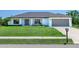 Charming single-story home featuring a well-manicured lawn, two-car garage and covered front porch at 6126 Spinnaker Blvd, Englewood, FL 34224