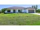 Beautifully landscaped single-story home with a two-car garage and inviting front porch at 6126 Spinnaker Blvd, Englewood, FL 34224