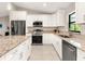 Bright kitchen features granite countertops, stainless steel appliances, and white cabinetry at 6126 Spinnaker Blvd, Englewood, FL 34224