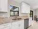 Kitchen featuring granite countertops, stainless steel dishwasher, and a bright window view at 6126 Spinnaker Blvd, Englewood, FL 34224