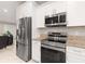 Modern kitchen equipped with stainless steel appliances and white cabinets for a sleek look at 6126 Spinnaker Blvd, Englewood, FL 34224