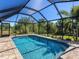 Secluded pool area featuring a screened lanai, providing a private oasis with lush surrounding greenery at 6126 Spinnaker Blvd, Englewood, FL 34224