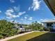 Backyard view showcasing waterfront access, a private dock, and mature landscaping on a sunny day at 617 Bonito Ave, Nokomis, FL 34275