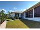 Exterior shot featuring a screened-in porch, well-maintained lawn, and brick pathway at 617 Bonito Ave, Nokomis, FL 34275