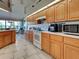 Functional kitchen boasting wood cabinetry, tile flooring, and modern appliances for easy meal preparation at 617 Bonito Ave, Nokomis, FL 34275