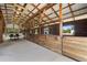 Interior of a wood paneled horse barn, showcasing the stalls and the building's wooden frame at 6824 283Rd E St, Myakka City, FL 34251