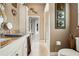 Bright bathroom with vanity, decorative mirror, and tiled floor leading to hallway at 6824 283Rd E St, Myakka City, FL 34251